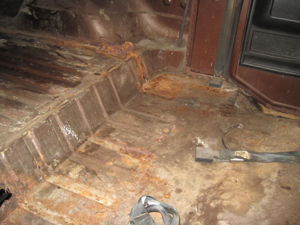 Rusted interior floor with seatbelt hardware