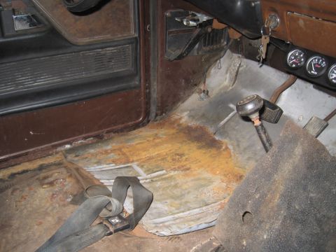 1979 Ford Bronco - Interior floor of a 1979 Ford Bronco with significant rust damage.