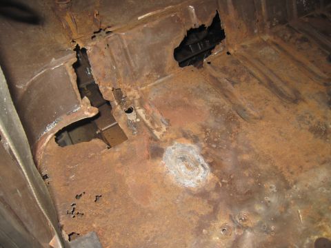 1979 Ford Bronco - The floor pan of this vehicle is heavily corroded, with significant rust and holes visible.