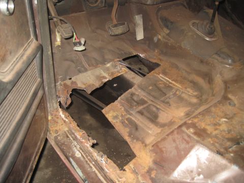 1979 Ford Bronco - The floor pan of this vehicle is heavily rusted, with large sections missing, revealing the undercarriage.