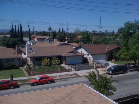 1968 Ford Mustang - A suburban street scene parked cars and residential homes under a bright, clear sky.