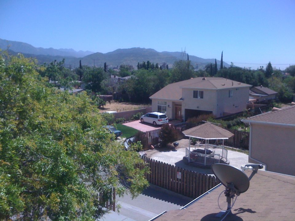 White minivan parked in driveway with mountains in background