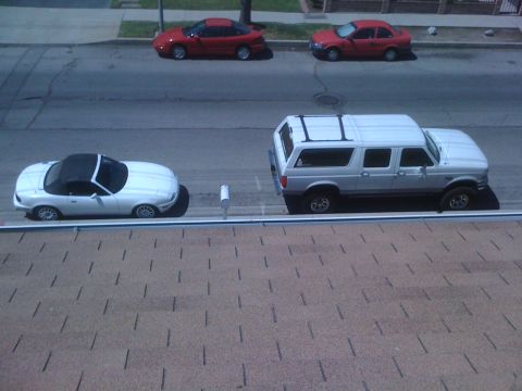 1968 Ford Mustang - A white convertible sports car and a white SUV are parked on a residential street.