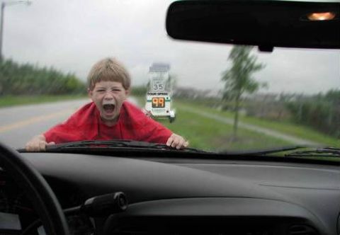 2002 Ford Taurus - View from a car's driver seat through the windshield, showing the dashboard, wiper arms and rearview mirror, with a screaming child appeari…