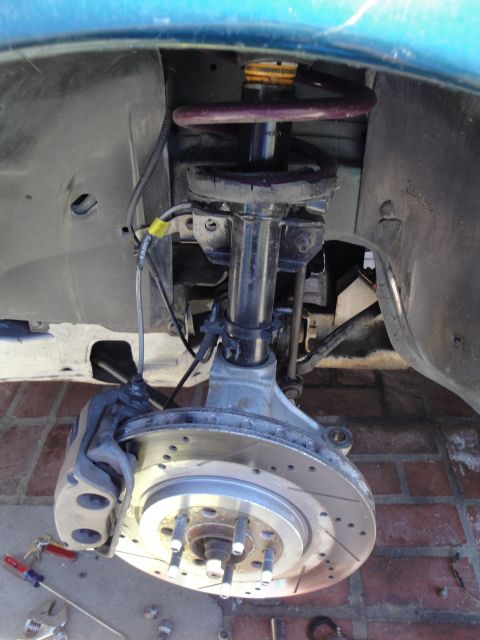 1995 Ford Taurus - Close-up view of a vehicle's front suspension system, showing the brake rotor and caliper.