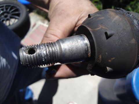 1995 Ford Taurus - A person holds a tie rod end part, showing its threaded end and ball joint housing.