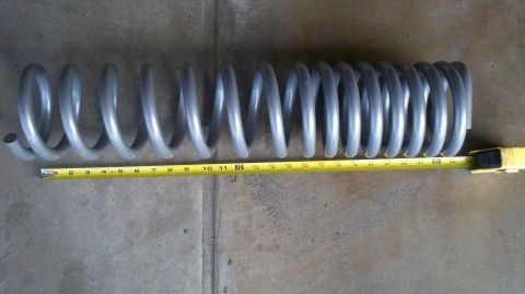 1996 Ford Bronco - A gray coil spring is shown with a yellow tape measure indicating its length.