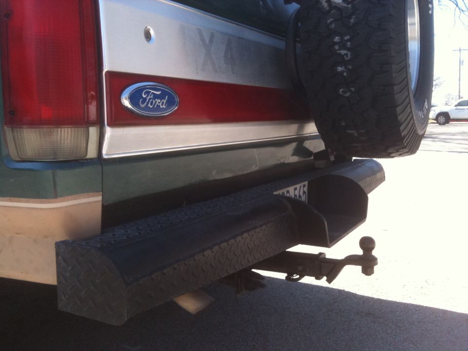 Green Ford Bronco rear bumper with spare tire mounted, tow hitch, and license plate
