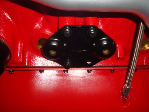 1989 Ford Bronco - Engine block detail showing a bolted black bracket and part of a silver pipe.