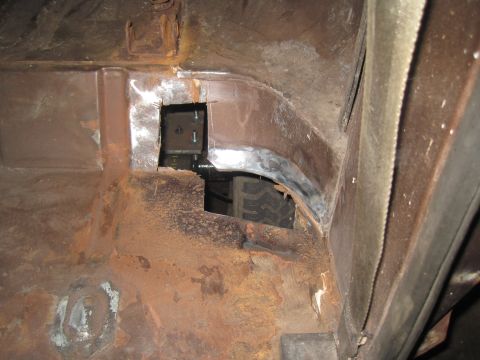 1979 Ford Bronco - View of the interior body panel, showing rust and a tire through an opening.