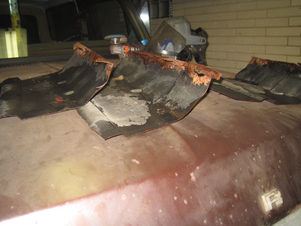 rusted metal pieces on a car hood, possibly from a fender or undercarriage