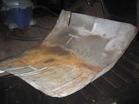 1979 Ford Bronco - A heavily rusted floor pan is shown, with a T-shaped mark visible on its surface.