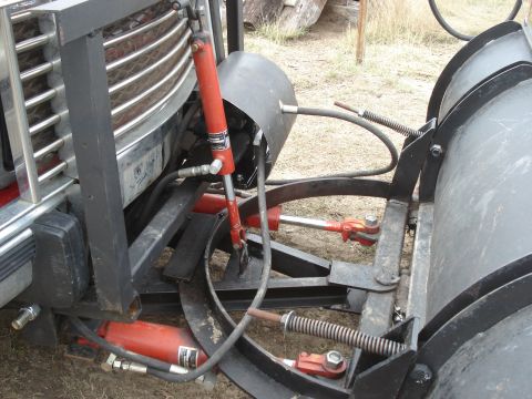 1994 GMC Sierra 3500 - Front view of a 1994 GMC Sierra 3500 equipped with a plow, showing hydraulic cylinders and the vehicle's grille.