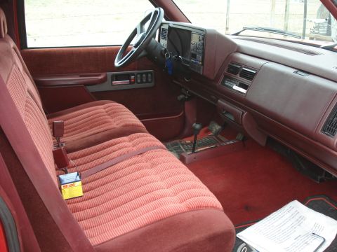 1994 GMC Sierra 3500 - Interior view of a red truck, showing the bench seat, dashboard, and steering wheel.