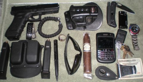 1993 Ford Bronco - A collection of personal items including a handgun, ammunition, and accessories is laid out on a textured surface.