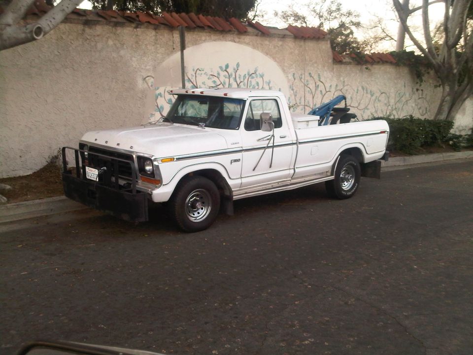 White Ford F-series pickup truck, looks like a 1979 model, parked on a street