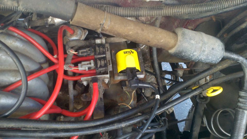 Yellow ACCEL ignition coil and red spark plug wires in engine bay