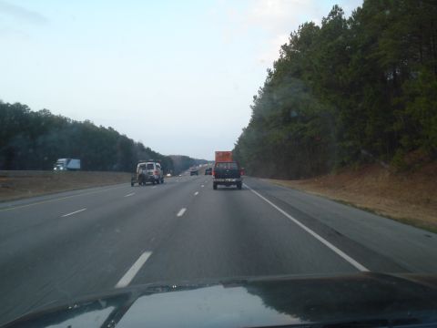 1989 Ford F-250 - View from inside a vehicle driving on a highway with other traffic and trees lining the road.