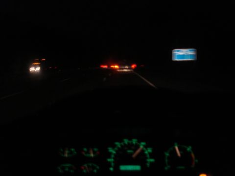1989 Ford F-250 - View from inside a vehicle at night, showing dashboard instruments and distant traffic on a highway.