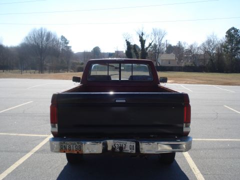 1989 Ford F-250 - This pickup truck has a two-tone paint scheme with a black tailgate and red body.