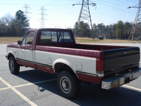 1989 Ford F-250 - This maroon and white Ford F-250 pickup truck is viewed from the rear three-quarter angle.