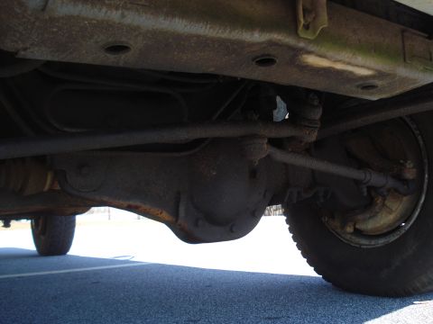 1989 Ford F-250 - Undercarriage view of a 1989 Ford F-250, highlighting the front axle, steering components, and suspension.