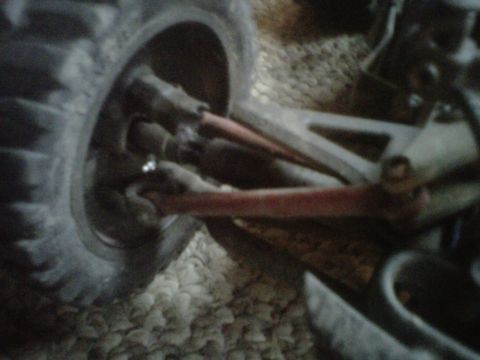2011 Ford 427 - Detail of a vehicle's suspension system, showing a red arm and tire.
