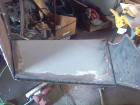 1989 Ford Bronco - Close-up view of a metal panel, possibly undergoing repair or fabrication, with visible welding marks and a light gray finish.