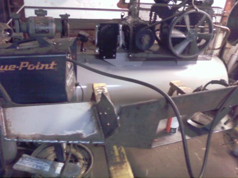 1989 Ford Bronco - An air compressor and welding equipment are visible in this workshop scene, with metal parts in the foreground.