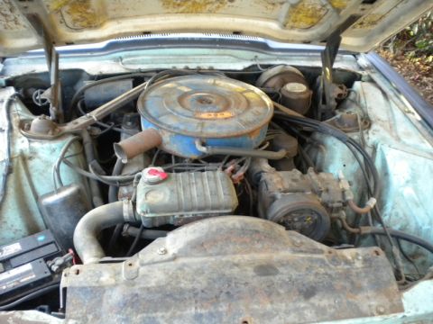 1965 Ford Thunderbird - The engine bay of a car, showing various mechanical parts and the air filter assembly.