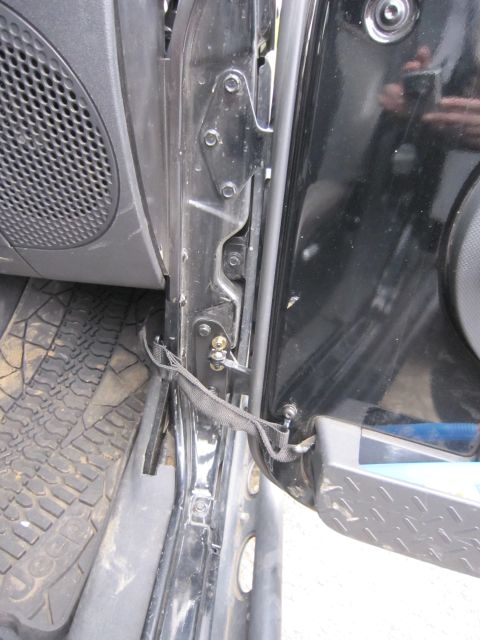 2008 Jeep Wrangler - Close-up view of the door hinge mechanism and interior of a Jeep.