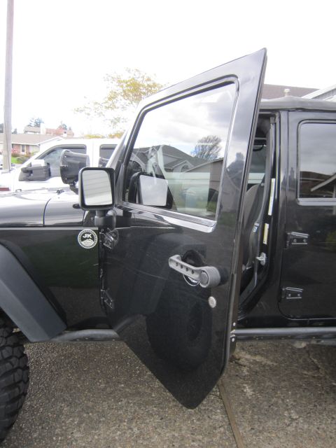 2008 Jeep Wrangler - A black Jeep Wrangler's driver's door is open, revealing the interior and a 'JK' badge on the fender.