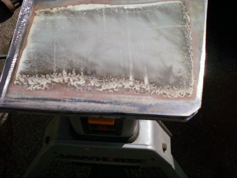 1989 Ford Bronco - Close-up of a corroded metal panel on a sawhorse, showing signs of rust and discoloration.