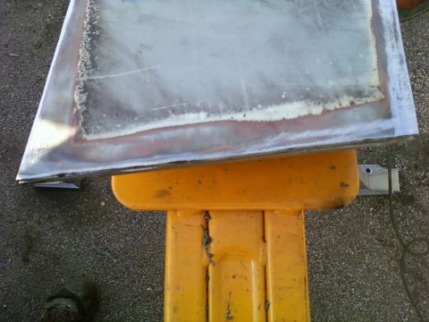 1989 Ford Bronco - A metal panel, possibly a car door or hood, is shown resting on a yellow stand.