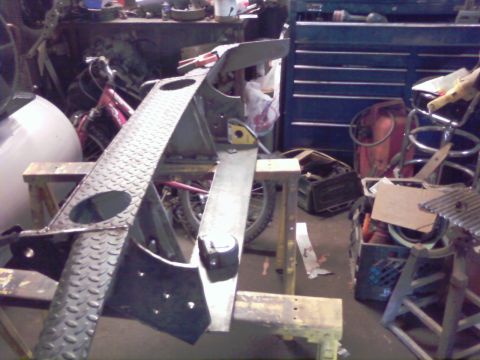 1989 Ford Bronco - Workshop scene with various metal components and tools, suggesting ongoing fabrication or repair work.