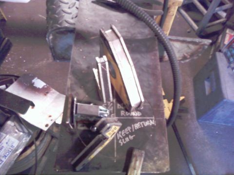 1989 Ford Bronco - A workbench surface shows various metal components and chalk markings, including instructions for slag.