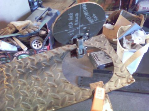 1989 Ford Bronco - A metal cutting disc is shown with various markings and measurements, placed on a textured metal surface in a workshop setting.
