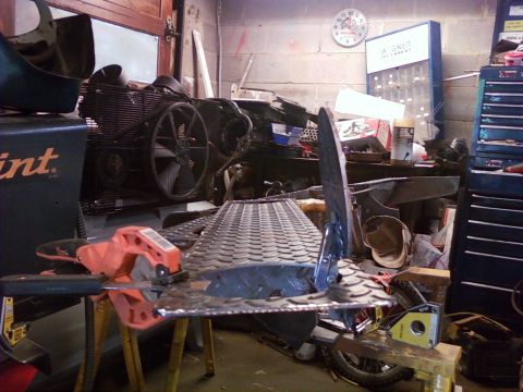 1989 Ford Bronco - Workshop scene with a metal fabrication project in progress, surrounded by tools and equipment.