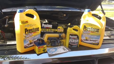 1994 Ford Bronco - Various Prestone cooling system maintenance products are displayed in front of an open vehicle hood.