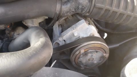 1994 Ford Bronco - Close-up of an engine component, possibly an AC compressor or water pump pulley with a belt.