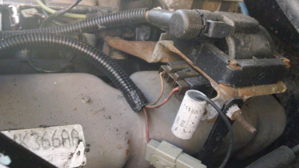 Close-up of engine wiring and a black electrical component with some rust