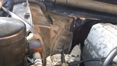 1994 Ford Bronco - Close-up view of an engine bay component, showing metal strapping and insulation material.
