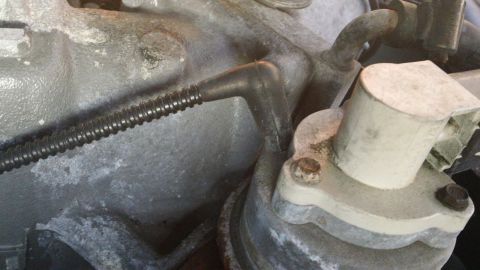1994 Ford Bronco - This is a close-up view of an engine component, possibly a sensor, with a black ribbed wire attached.
