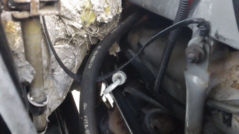 1994 Ford Bronco - Close-up view of engine bay cooling system hoses, with some text visible on the black hose.