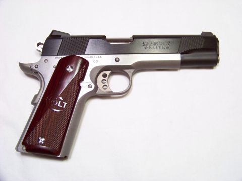 1995 Mercury Grand Marquis - A Colt Combat Elite pistol is shown with its distinctive wood grips and silver frame.