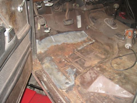 1979 Ford Bronco - Vehicle interior floor shows extensive rust damage and repair work in progress.