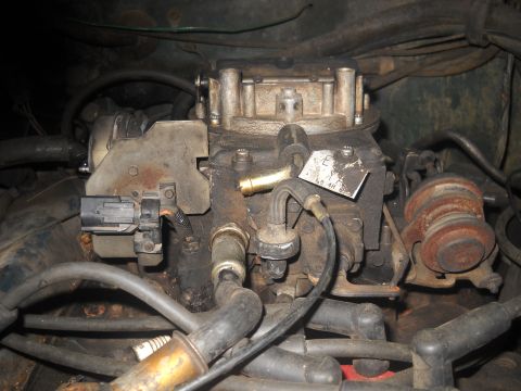 1982 Ford Bronco - Engine carburetor with visible wiring and hoses, part of a larger engine assembly.
