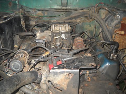 1982 Ford Bronco - Close-up view of a vehicle's engine bay, focusing on the carburetor and associated components.