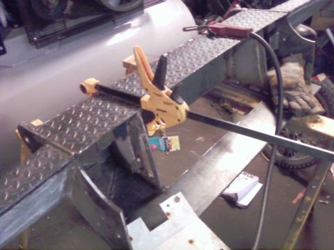 1989 Ford Bronco - A metal frame with diamond plate texture is secured by yellow clamps, suggesting ongoing fabrication or repair work.