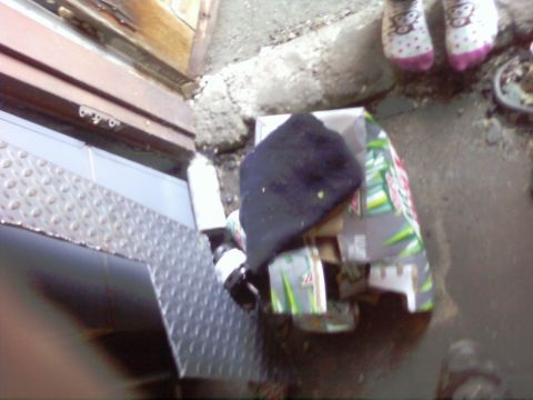 1989 Ford Bronco - A black hat rests on top of discarded packaging and other debris on a wet surface.